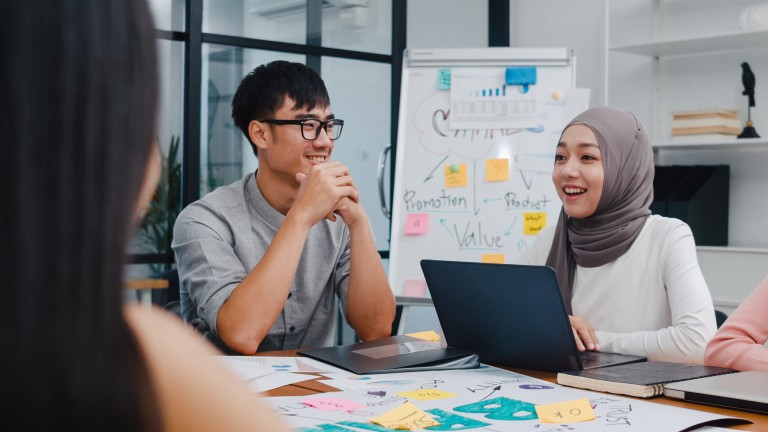 Multiracial group of young creative people in smart casual wear discussing business brainstorming meeting ideas mobile application software design project in modern office. Coworker teamwork concept. Multiracial group of young creative people in smart casual wear